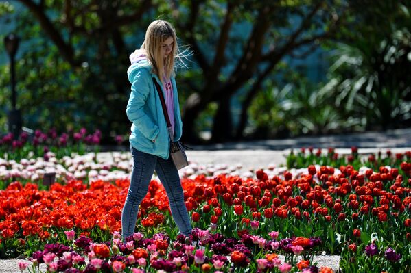 Девушка любуется цветами в Никитском ботаническом саду в Крыму - Sputnik Латвия