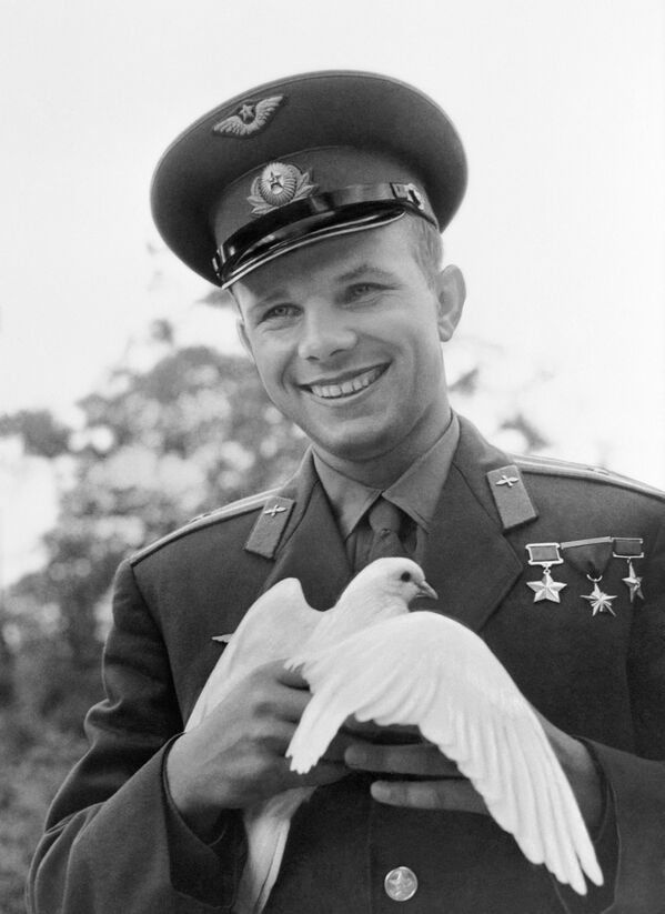 Летчик-космонавт Юрий Гагарин держит голубя, подаренного ему болгарскими пионерами - Sputnik Латвия