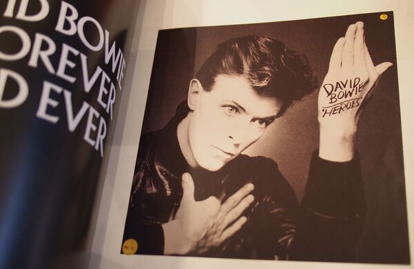 Портрет Дэвида Боуи на развороте альбома с его фотографиями Портрет Дэвида Боуи на развороте альбома с его фотографиями - Sputnik Латвия