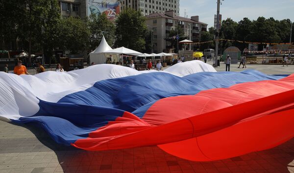 Zibakcijas Es mīlu Krieviju dalībnieki izritina milzīgu karogu Galvenajā pilsētas laukumā Krasnodarā - Sputnik Latvija