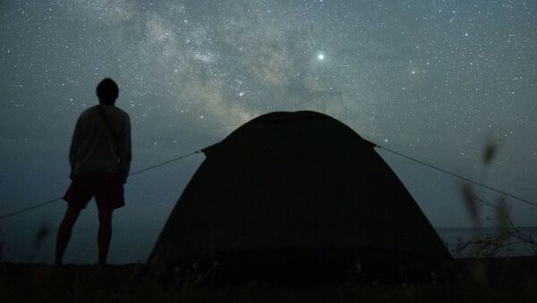 Мужчина наблюдает за звездным небом на берегу Черного моря возле поселка Морское в Крыму - Sputnik Latvija