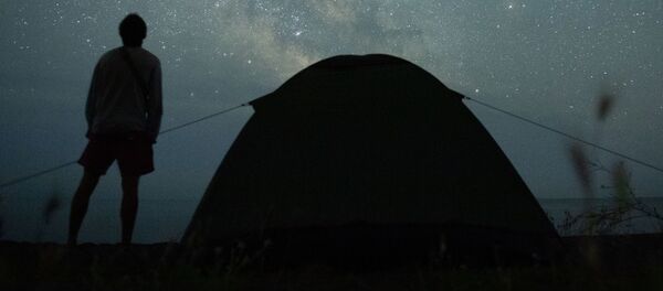 Мужчина наблюдает за звездным небом на берегу Черного моря возле поселка Морское в Крыму Мужчина наблюдает за звездным небом на берегу Черного моря возле поселка Морское в Крыму - Sputnik Latvija