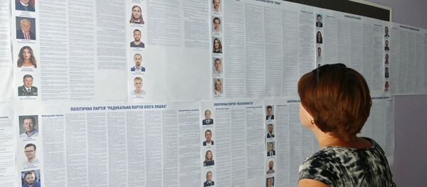 Женщина изучает списки кандидатов на пост депутата в Верховную раду Украины на участке в Черкассах. На Украине проходят досрочные выборы в Верховную раду.  - Sputnik Latvija
