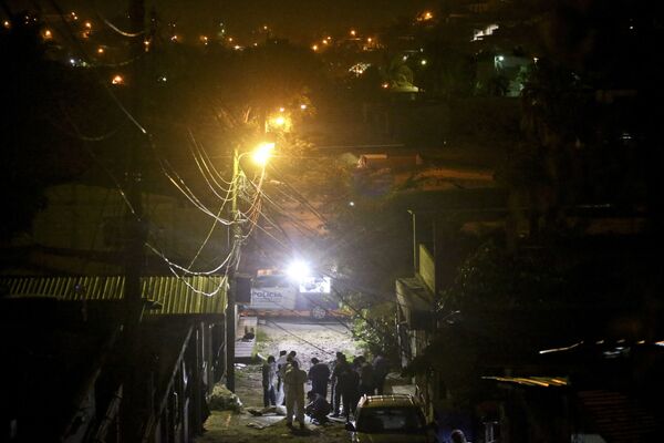Полицейские на месте убийства молодого юноши в районе Chamelecon города Сан-Педро-Сула, Гондурас. - Sputnik Латвия