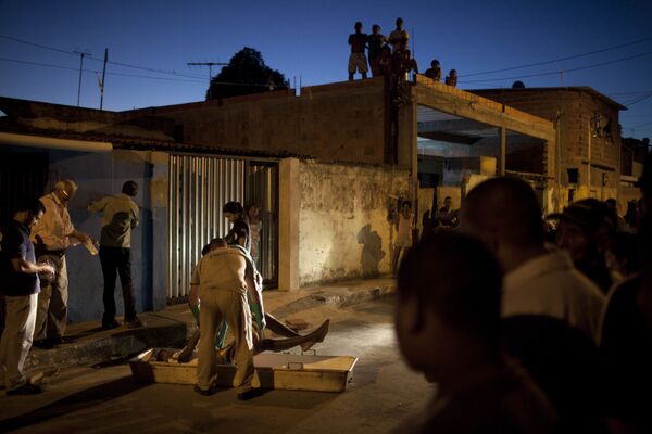 Работники морга забирают тело мужчины, погибшего во время стрельбы в районе Итинга в Сальвадоре, Бразилия. - Sputnik Латвия