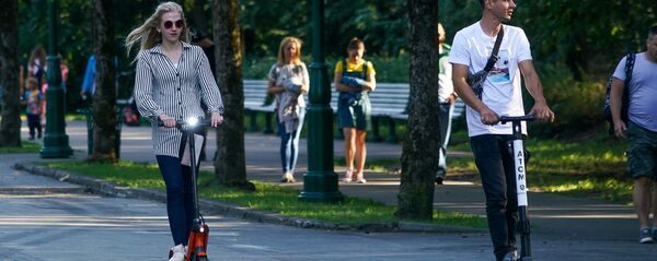 Молодые люди на прокатных электросамокатах - Sputnik Latvija