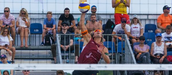 Этап Кубка мира по пляжному волейболу в Юрмале. Латвийский волейболист Александр Самойлов подает силовую подачу - Sputnik Латвия