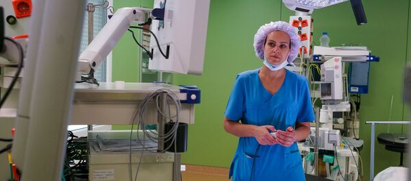 Операционная сестра готовит оборудование к операции - Sputnik Латвия