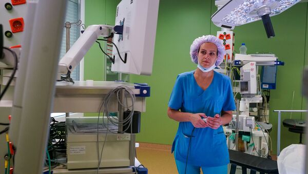 Операционная сестра готовит оборудование к операции - Sputnik Латвия