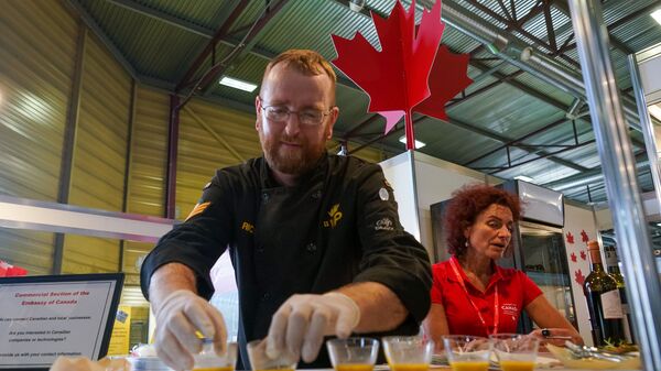 На стенде Канады готовит шеф-повар канадского контингента, базирующегося в Адажи - Sputnik Латвия