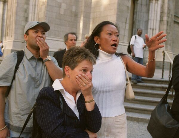 Люди на улице наблюдают за происходящим в башнях Всемирного торгового центра после теракта 11 сентября 2001 года - Sputnik Латвия
