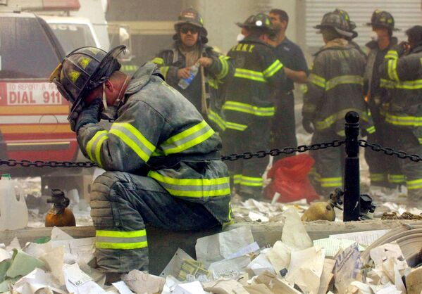 Пожарный плачет возле Всемирного торгового центра в Нью-Йорке, подвергшегося террористической атаке 11 сентября 2001 года - Sputnik Латвия