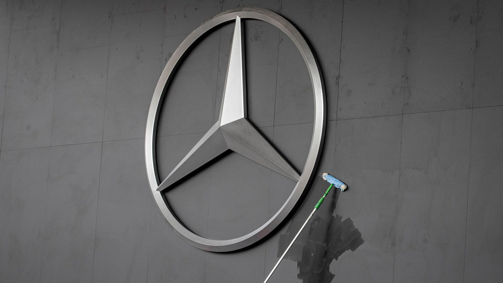Работник протирает логотип Mercedes на автосалоне IAA во Франкфурте, Германия - Sputnik Латвия, 1920, 19.11.2021