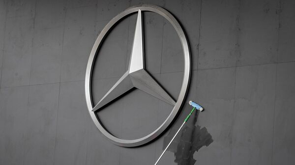 Работник протирает логотип Mercedes на автосалоне IAA во Франкфурте, Германия - Sputnik Латвия