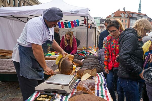 Торговцы в День Микелиса щедро нарезают хлеб  - Sputnik Латвия