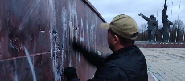 Общественник смывает надпись оккупанты с памятника Освободителям - Sputnik Latvija