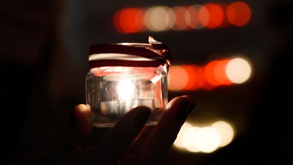 Рижане зажигают поминальные свечи у стены Рижского замка в День Лачплесиса - Sputnik Latvija