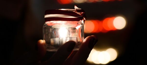 Рижане зажигают поминальные свечи у стены Рижского замка в День Лачплесиса Рижане зажигают поминальные свечи у стены Рижского замка в День Лачплесиса - Sputnik Latvija