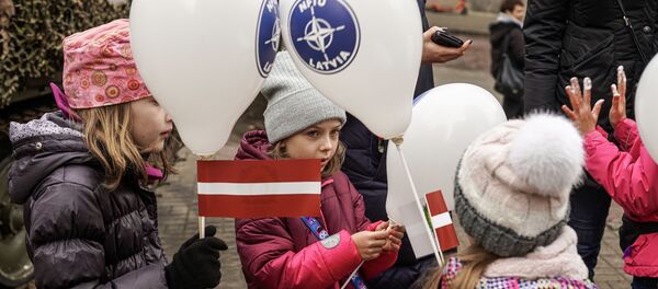 Bērni ar NATO integrācijas spēku vienības (NFIU) baloniem un Latvijas karogiem Lāčplēša dienā Bērni ar NATO integrācijas spēku vienības (NFIU) baloniem un Latvijas karogiem Lāčplēša dienā - Sputnik Latvija