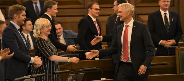 Юта Стрике и Кришьянис Кариньш собираются пожать руки, радуясь принятию бюджета - Sputnik Латвия
