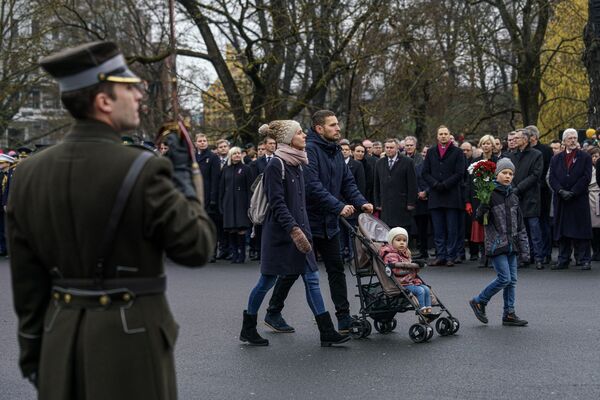 Семья с детьми проходит к памятнику Свободы, чтобы возложить цветы - Sputnik Латвия