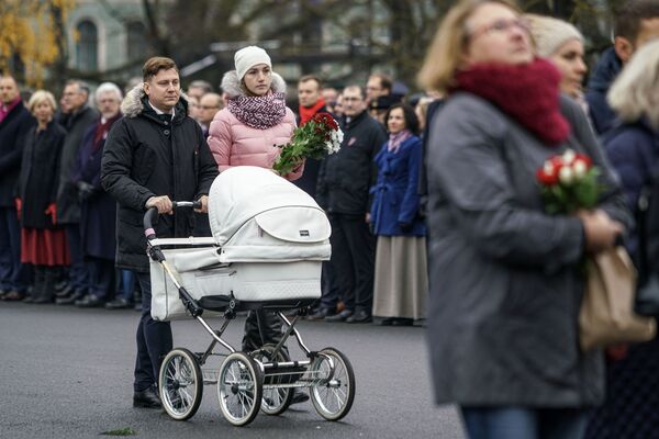 Семья с ребенком идет к памятнику Свободы, чтобы возложить цветы - Sputnik Латвия