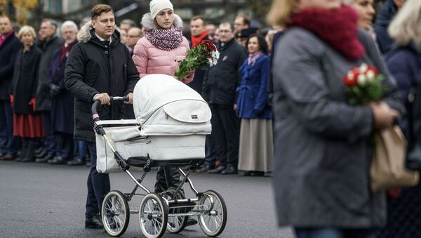 Семья с ребенком проходит к памятнику Свободы, чтобы возложить цветы - Sputnik Latvija