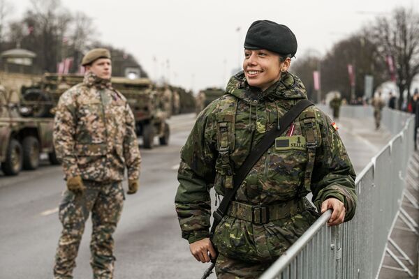 Военнослужащая из Испании фотографируется перед парадом в Риге в День независимости Латвии - Sputnik Латвия