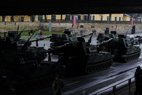 Латвийские самоходные гаубицы М109 выстроились в парадном строю под Вантовым мостом в Риге в ожидании начала прохождения войск - Sputnik Латвия