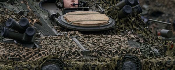 Механик-водитель латвийской БМП CVRT во время военного парада в Риге в День независимости Латвии Механик-водитель латвийской БМП CVRT во время военного парада в Риге в День независимости Латвии - Sputnik Latvija
