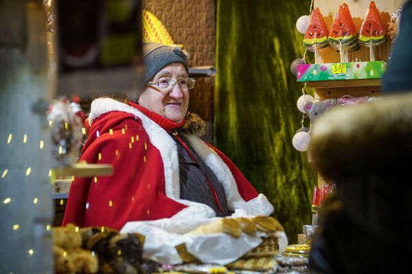 Продавщица на рождественской ярмарке на Домской площади в Риге. - Sputnik Латвия