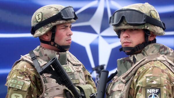Военнослужащие на фоне эмблемы NATO - Sputnik Латвия