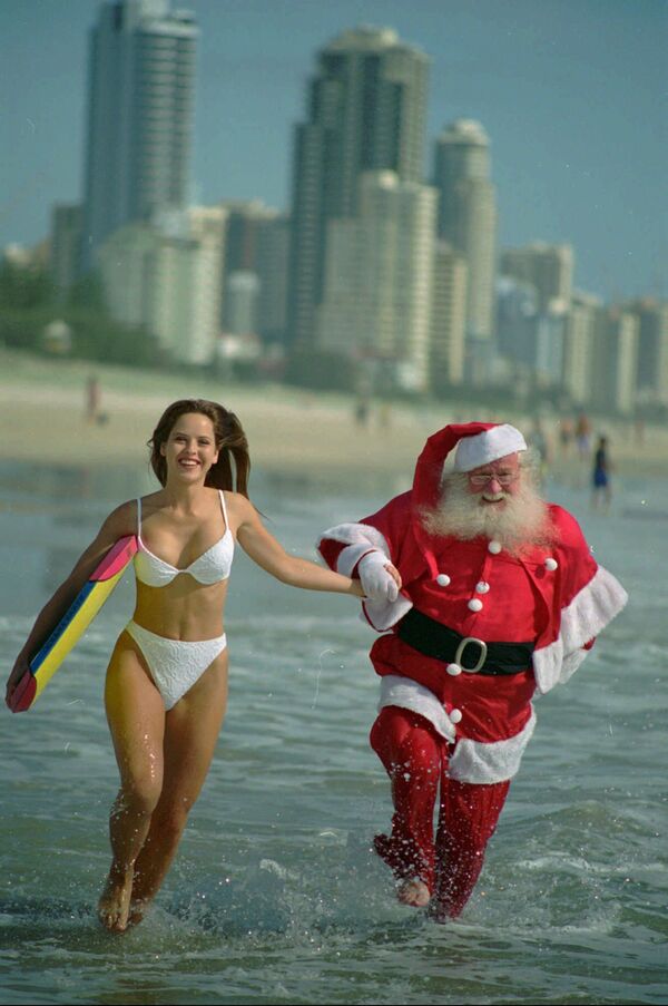 Австралийка и Санта-Клаус на пляже, считающемся раем для серферов. Квинсленд, Австралия, 1995 год. - Sputnik Латвия
