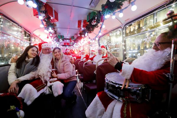 Музыканты в костюмах Санта-Клауса в автобусе в Санкт-Петербурге. - Sputnik Латвия