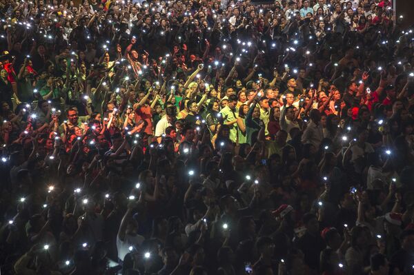 Христиане с зажженными фонарями на телефонах во время рождественской мессы в Индонезии. - Sputnik Латвия