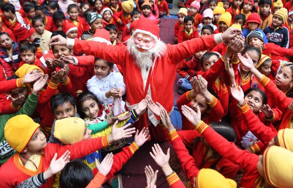 Девушка в костюме Санта-Клауса раздает подарки детям в Индии. - Sputnik Латвия