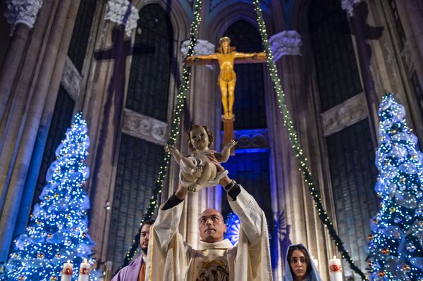 Священник со статуей младенца Христа во время рождественской мессы в Стамбуле. - Sputnik Латвия