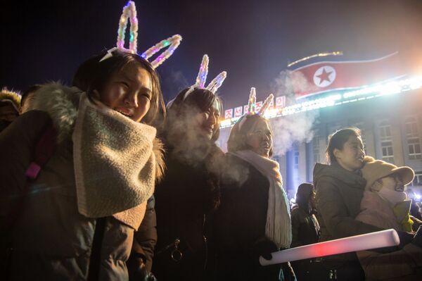 Девушки смотрят запуск салюта во время празднования Нового года в КНДР  - Sputnik Латвия