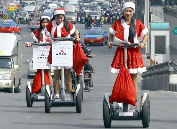Работницы отеля в костюмах Санта-Клауса во время раздачи подарков в Бангкоке  - Sputnik Латвия