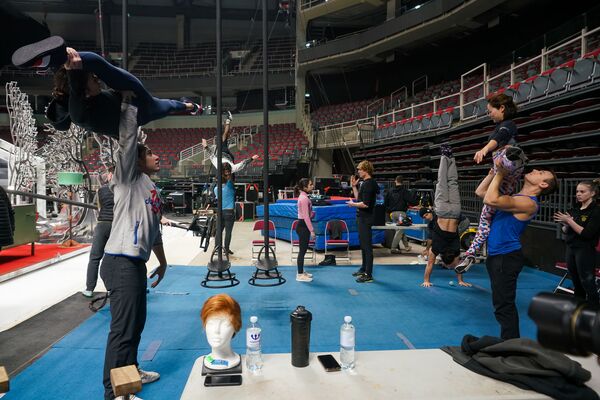 Артисты цирка, среди которых немало профессиональных спортсменов мирового уровня, проводят разминку на фирменных синих коврах. - Sputnik Латвия