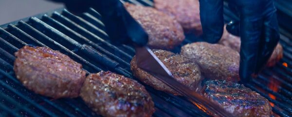 Сочные говяжьи котлеты для бургеров на  фестивале уличной еды Street Food Festival в Риге готовят на гриле. - Sputnik Латвия