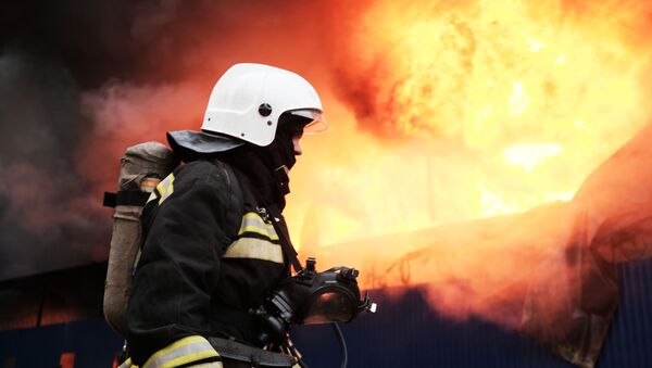 Сотрудник МЧС во время тушения пожара - Sputnik Latvija