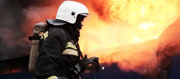 Сотрудник МЧС во время тушения пожара Сотрудник МЧС во время тушения пожара - Sputnik Latvija