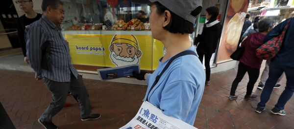 Раздача газет с новостями о коронавирусе в Гонконге  - Sputnik Латвия