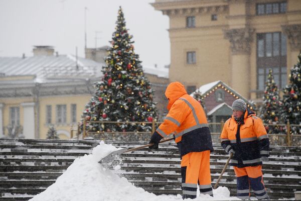 Сотрудники коммунальной службы чистят тротуары от снега в Москве - Sputnik Латвия