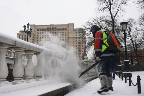 Сотрудник коммунальной службы чистит парапет у Александровского сада в Москве от снега - Sputnik Латвия
