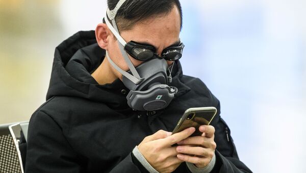 Пассажир в очках для плавания и маске на железнодорожной станции в Гонконге - Sputnik Латвия