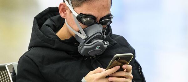 Пассажир в очках для плавания и маске на железнодорожной станции в Гонконге - Sputnik Латвия