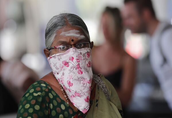 Индийская женщина с платком на лице в аэропорту Коломбо, Шри-Ланка - Sputnik Латвия