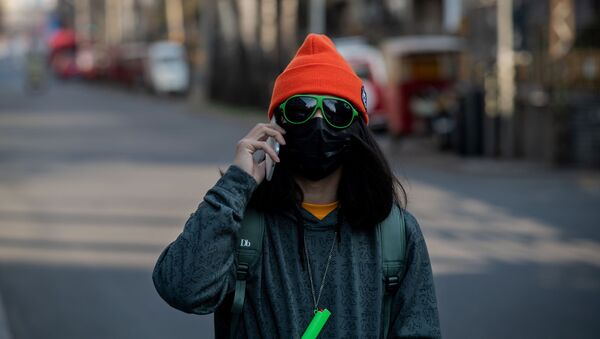 Девушка в маске и очках на пустынной улице Пекина  - Sputnik Латвия